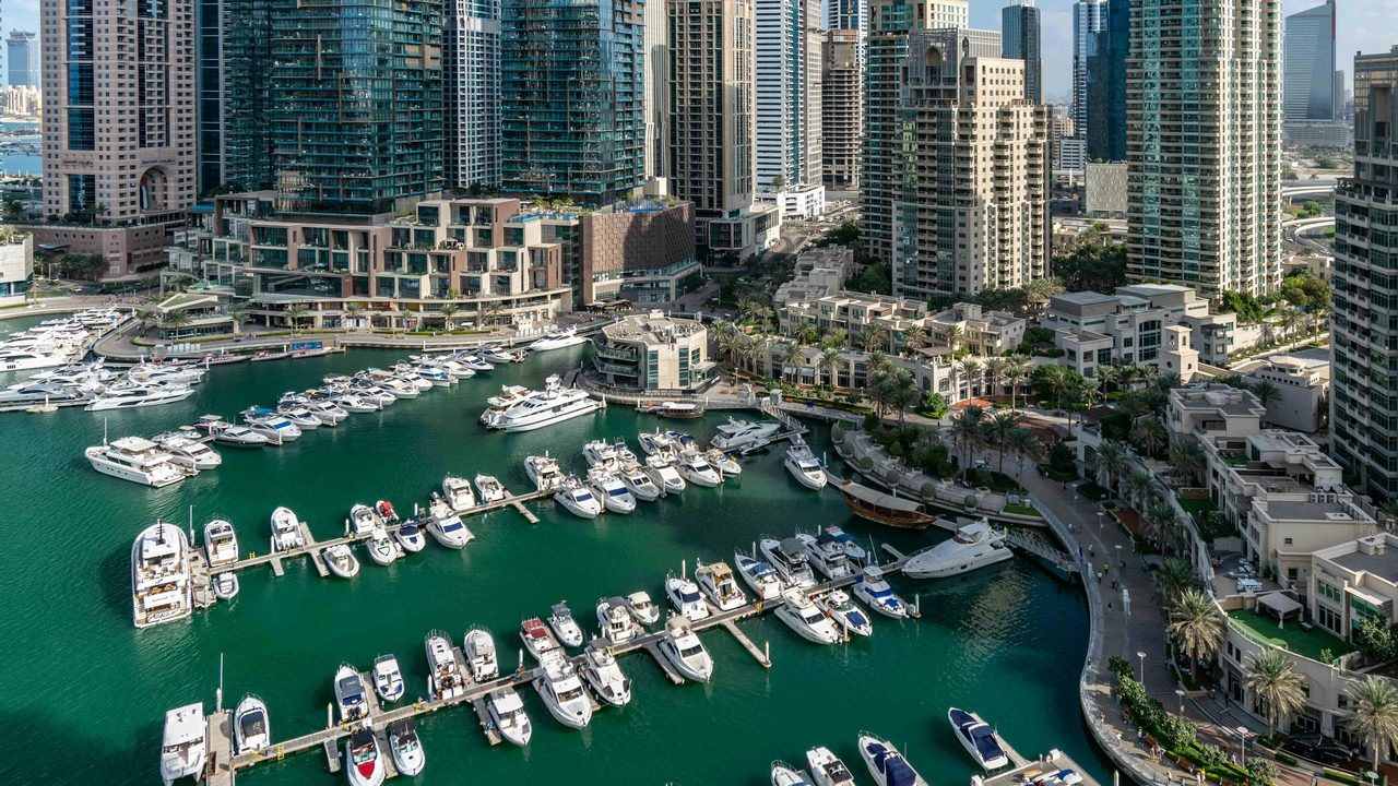 Yachts moored in Dubai Marina between residential towers