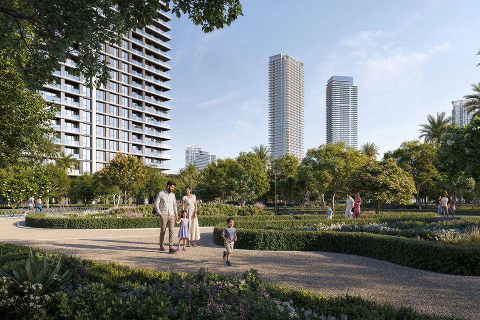Residential tower beside a landscaped park path with Dubai Creek Harbour towers behind
