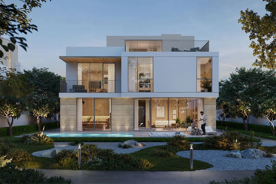 Two-storey white villa with a landscaped front garden at dusk
