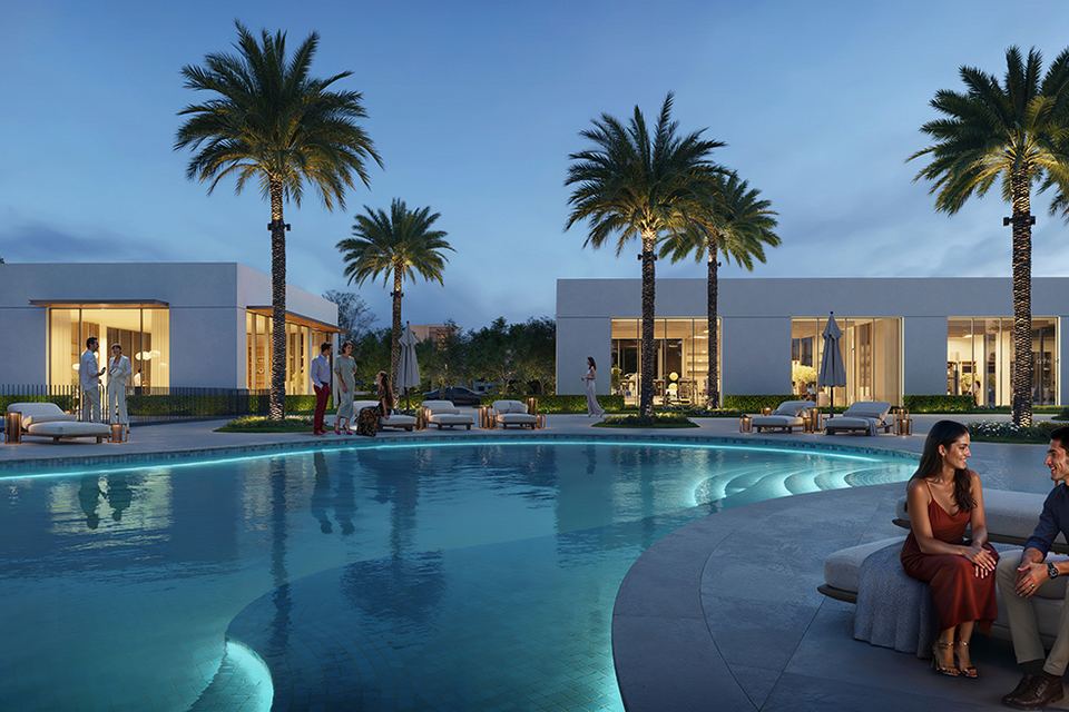 Community pool with palm trees and villas behind at dusk